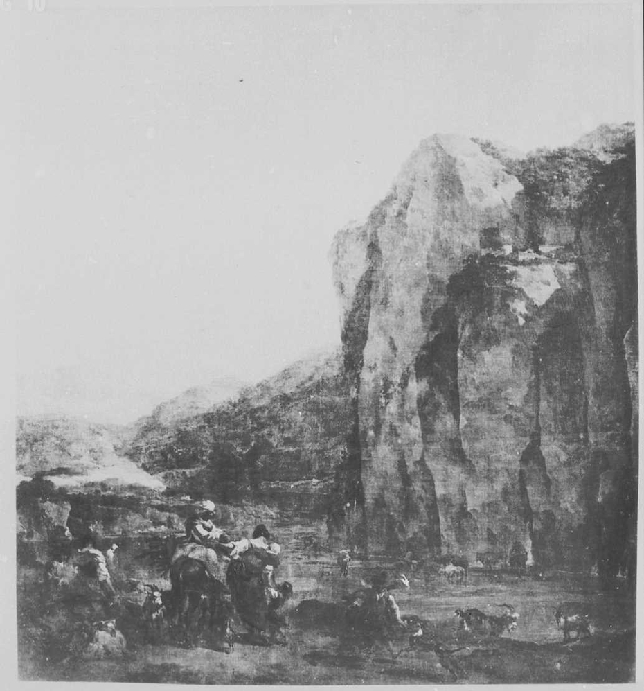 Shepherd watering cattle at the foot of a steep rock wall