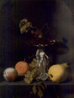 Still life with fruit and grapes in a silver Hercules tazza on a stone ledge