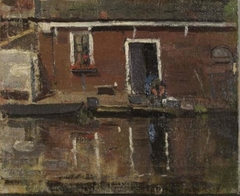 House façade on the water with woman washing