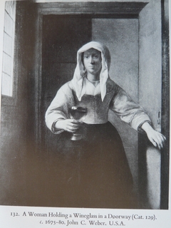 A Woman Holding a Wineglass in a Doorway