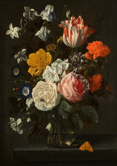 Flowers in a glass vase, with a tiger moth, on a stone ledge