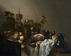 Still life with ham, fruit, akelei cup, drinking horn and lemon on a tablecloth by Willem Claesz Heda