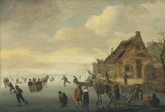 A winter landscape with horse-drawn sledges and figures skating on a frozen lake by a rural village